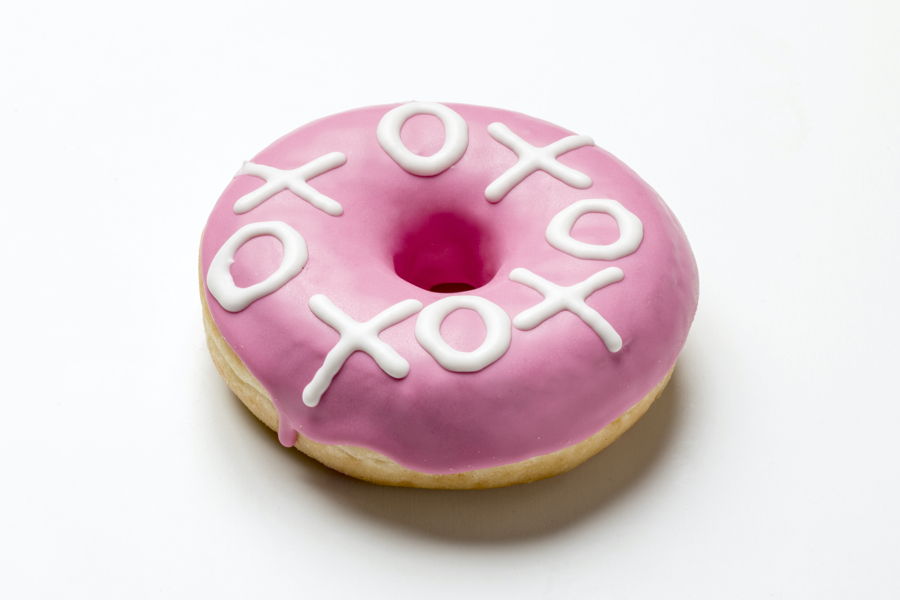 Pink donut decorated with white chocolate by a FoodJet decoration depositor