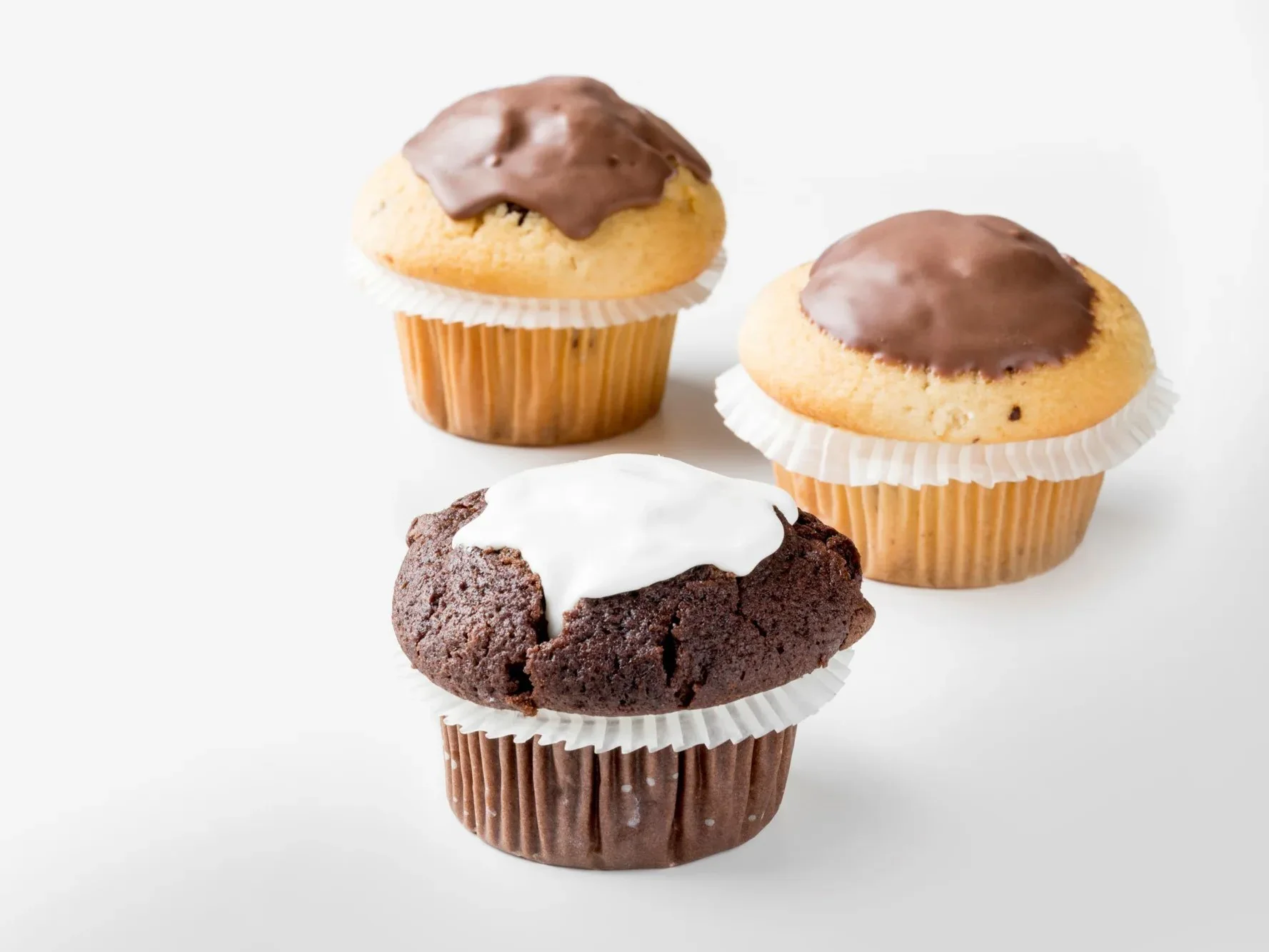 Three muffins topped with chocolate