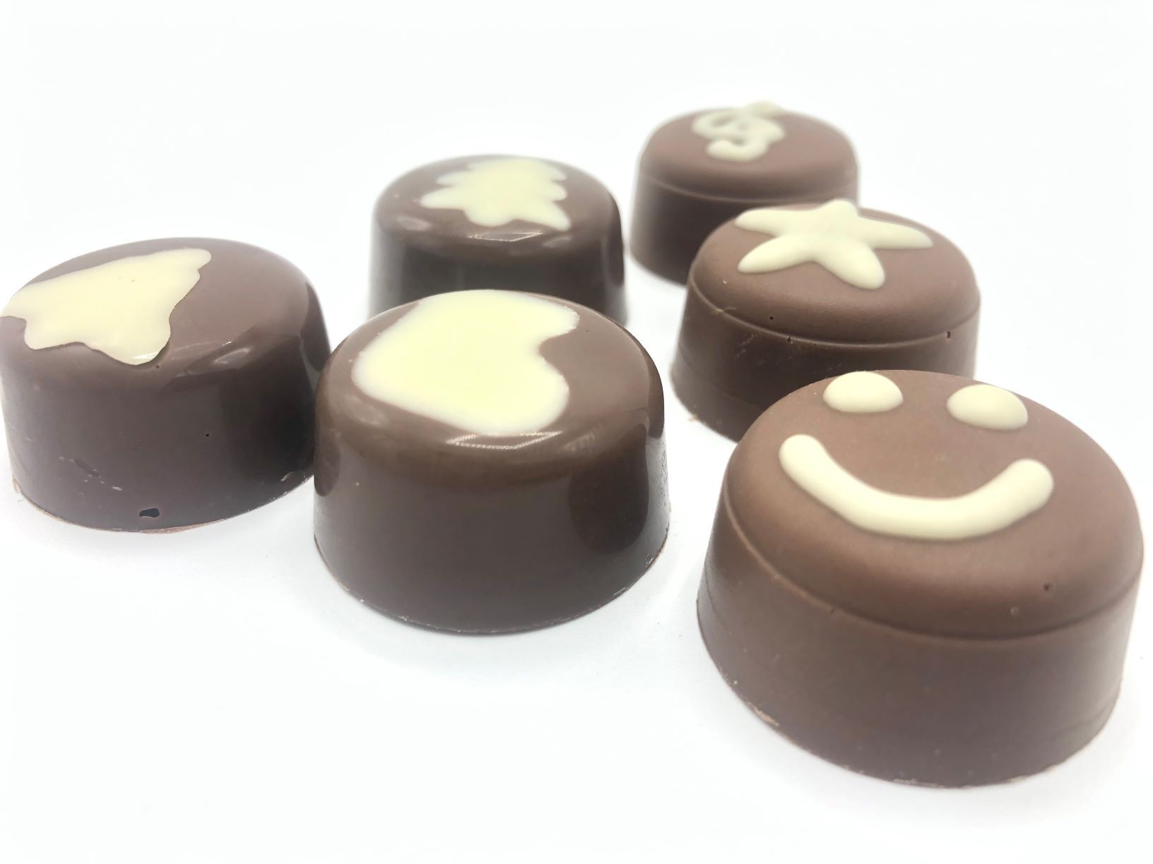 Six milk chocolate pralines decorated with white milk chocolate by FoodJet chocolate depositor