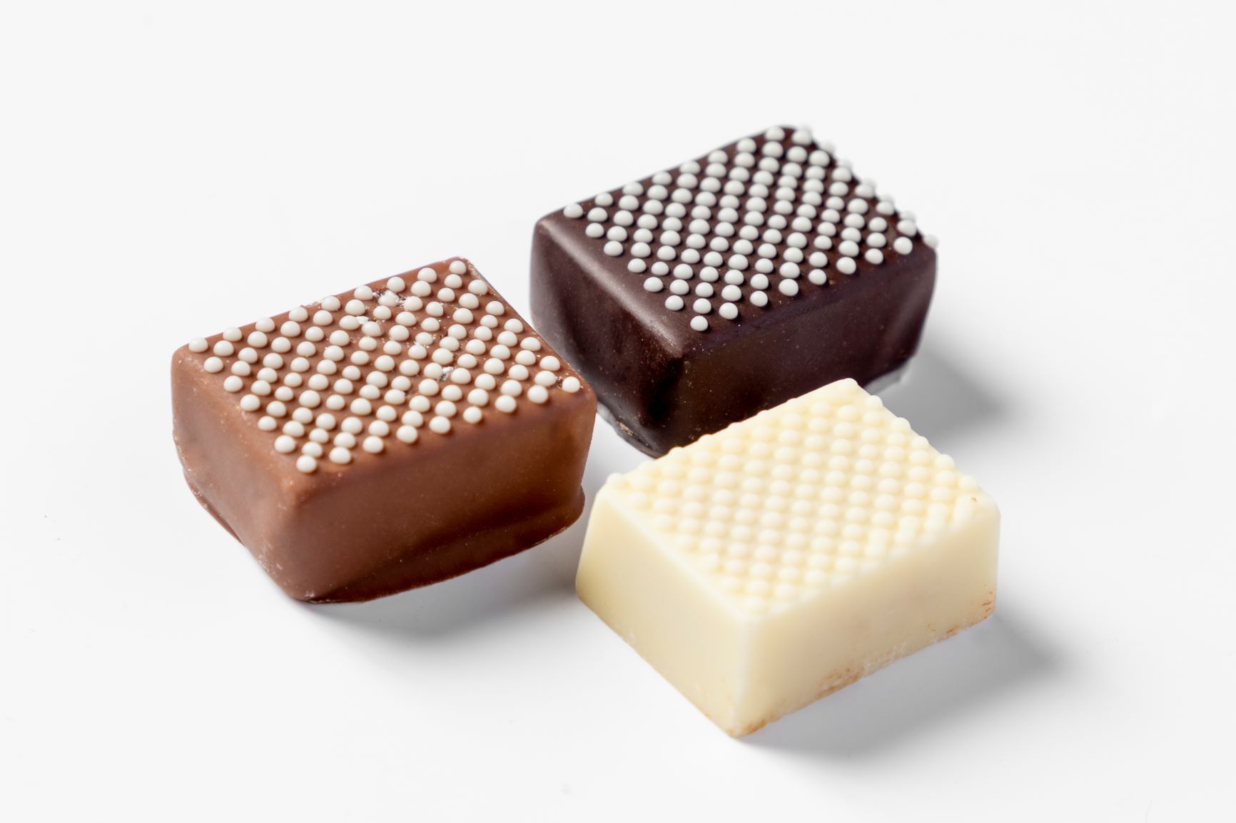 Three chocolate pralines decorated with a FoodJet chocolate depositor