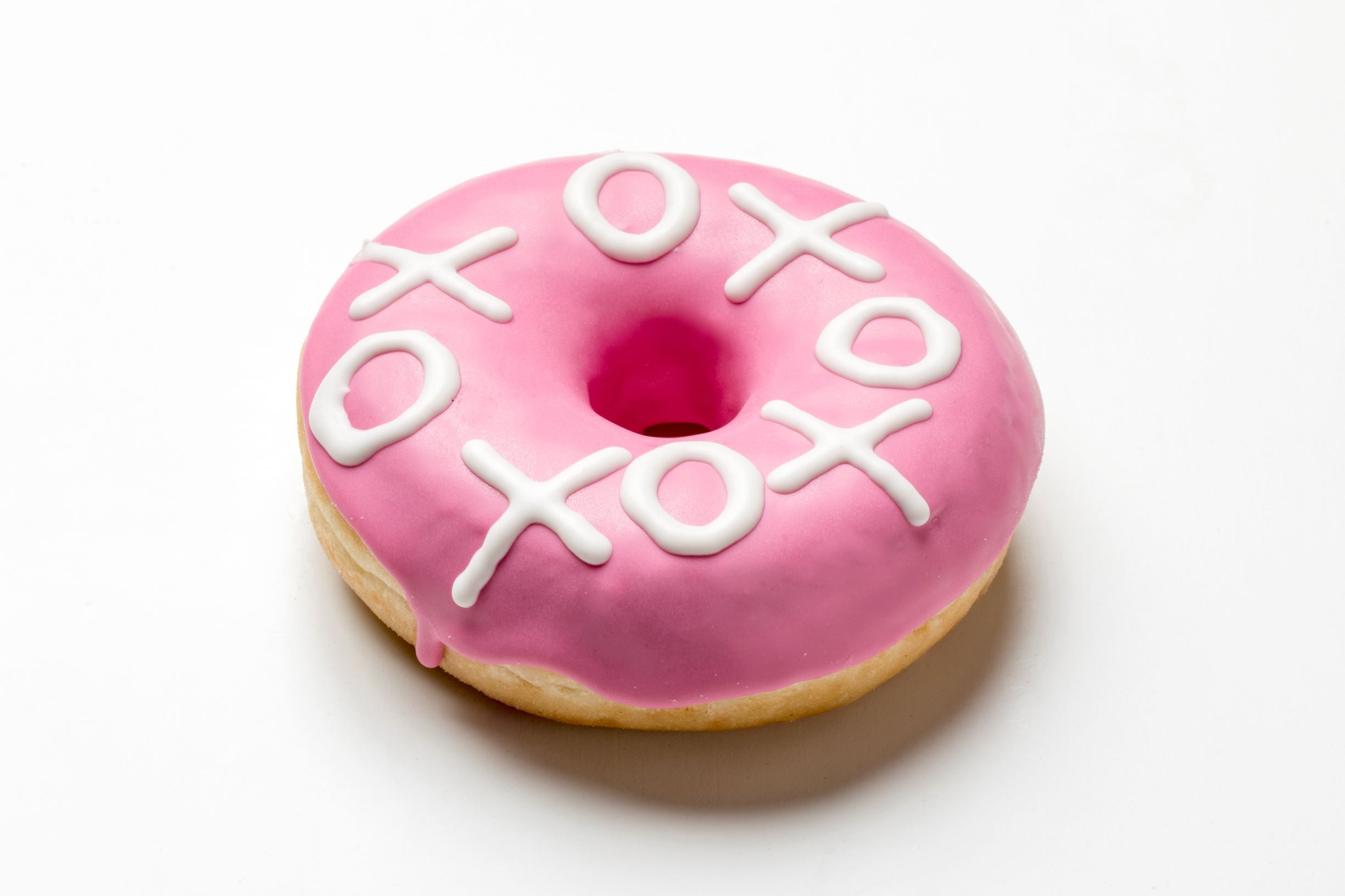 Donut enrobed in pink chocolate with tic-tac-toe printed on top in white chocolate by FoodJet chocolate depositor