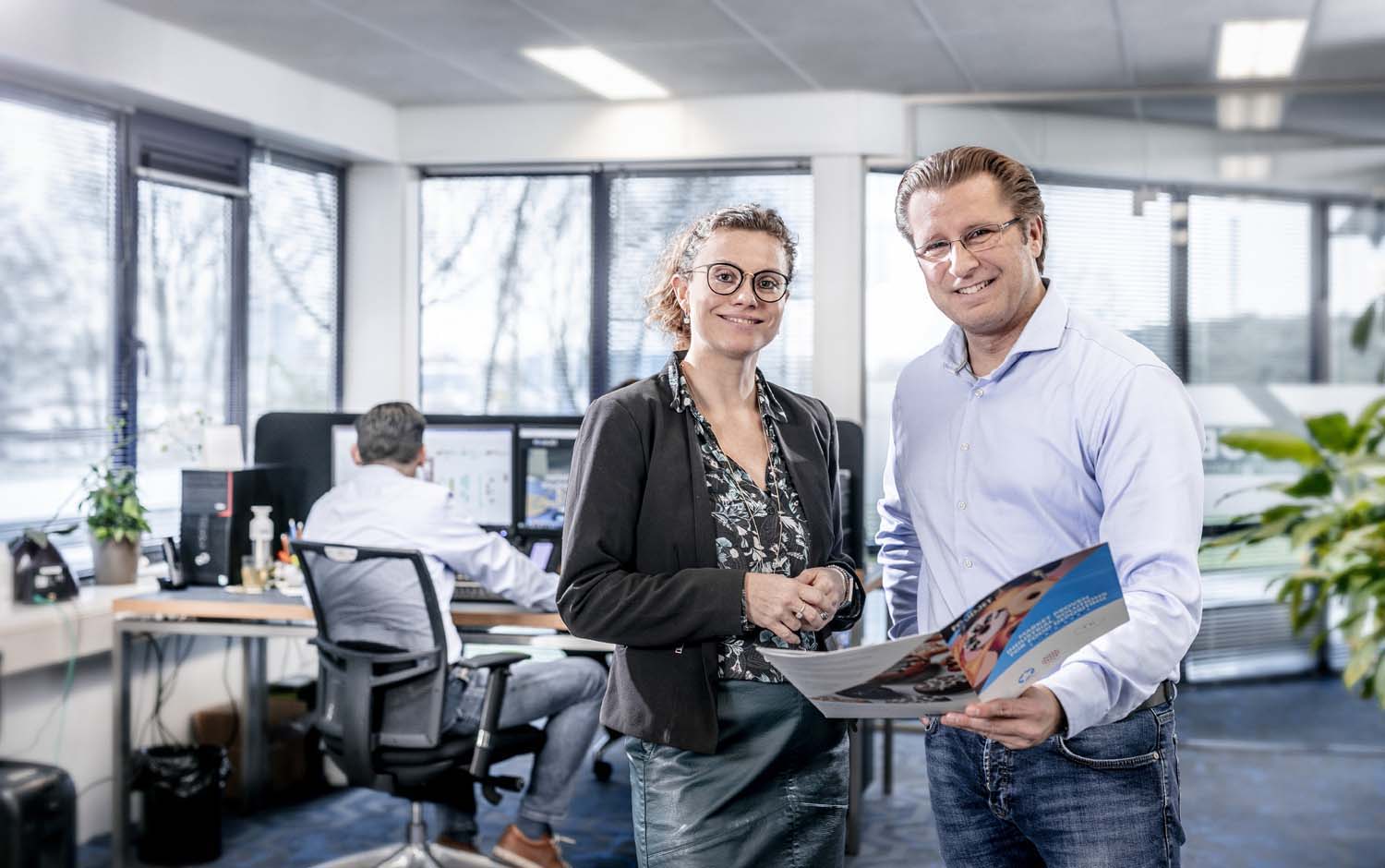 Two FoodJet employees looking happy holding a sales brochure in their hands