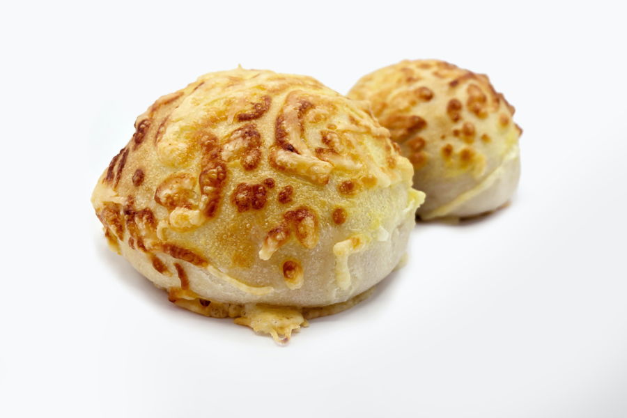 Two buns covered with liquid cheese by a FoodJet precision depositor