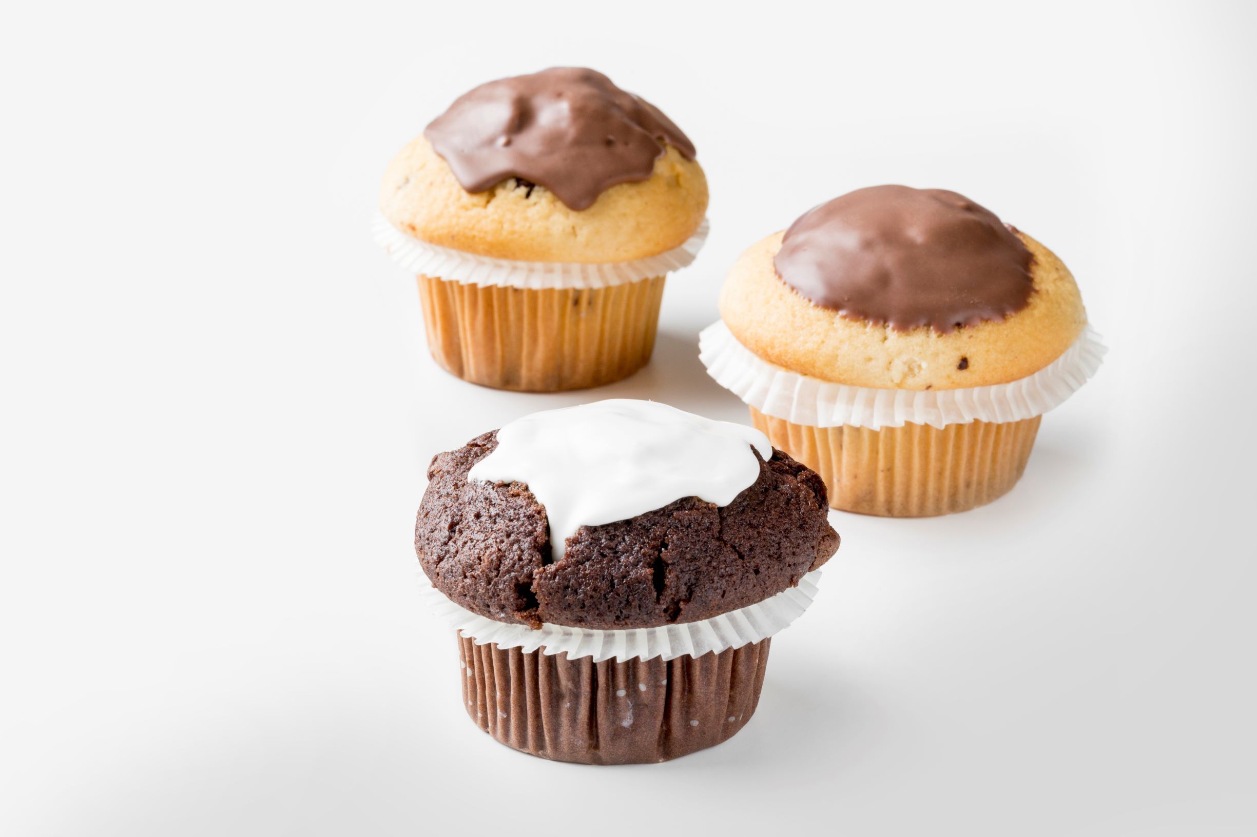 Three muffins covered with white and milk chocolate by FoodJet chocolate depositor