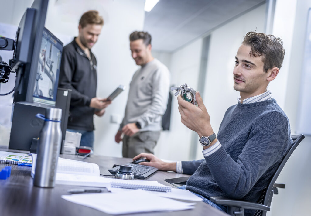 FoodJet engineers in the office, one inspecting a machine part at a desk