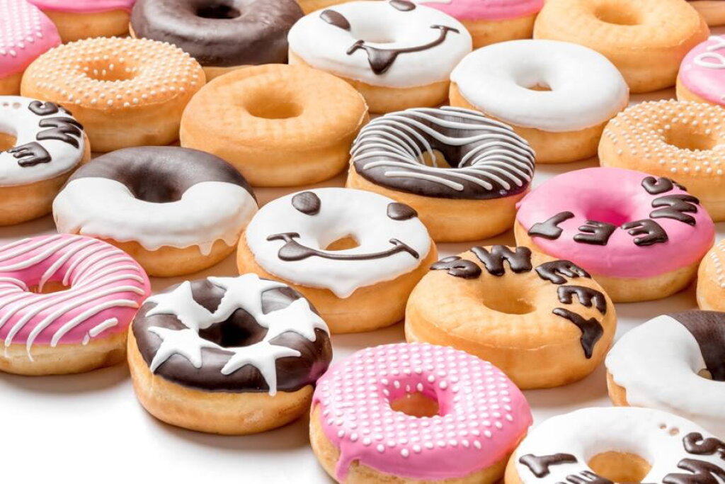 Donuts decorated with pink, white and dark chocolate compound, with dots, stars and lettering