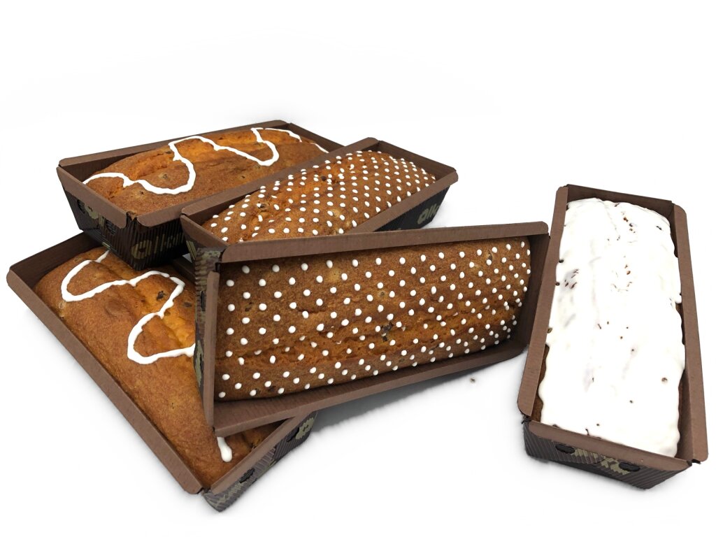 Loaf cakes in paper baking moulds with white decorations: zigzag lines, a raster of dots and a full layer